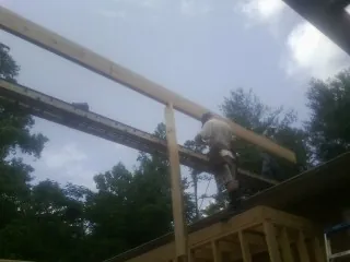 Carpenter setting a ridge beam over a new addition frame — Ice Dam Removal by Roofing Brothers in Dane