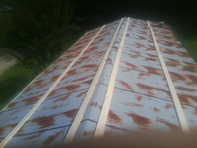 Rusted metal roof panels with new wood purlins before replacement — Storm Damage Roof Repair in Dane by Roofing Brothers